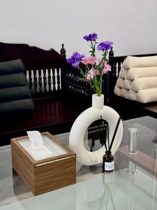 a white vase with purple flowers on a table at Soulstay Bangkok in Bangkok