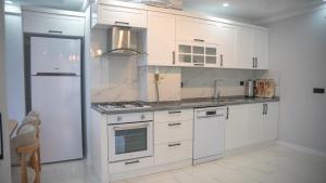 a kitchen with white cabinets and a refrigerator at Santana Suıts in Trabzon
