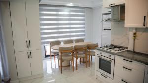 a kitchen with a table and chairs in a kitchen at Santana Suıts in Trabzon +39 photos
