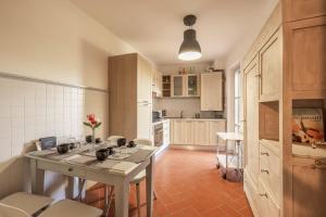 a kitchen with a table and chairs in a room at Aiuola133 in Cetona