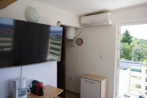 a room with a large flat screen tv on the wall at One Bedroom Apartment in Banjol