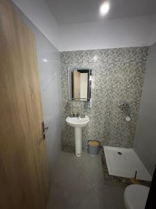 a bathroom with a sink and a toilet and a mirror at Complex riad tanger in Hajreien