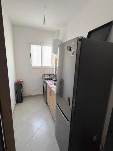 a kitchen with a stainless steel refrigerator and a stove at Complex riad tanger in Hajreien