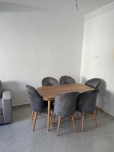 a dining room table with four chairs around it at Complex riad tanger in Hajreien +4 photos