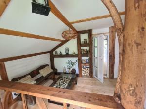 a living room with wooden floors and a ceiling with beams at Хатка у долині in Kosiv