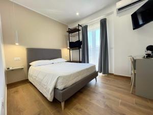 a bedroom with a bed and a television in it at Kalispera Rooms in Scalea