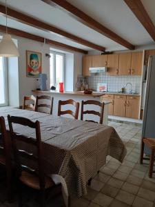 a kitchen with a table and chairs in a kitchen at La grande escapade in Xertigny