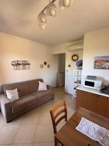 a living room with a couch and a table at Carpa House in Valledoria