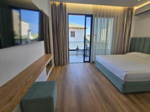 a hotel room with a bed and a balcony at Rei Hotel in Borsh