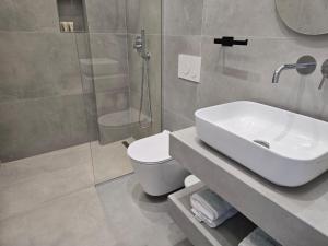 a bathroom with a sink and a toilet and a shower at Rei Hotel in Borsh +54 photos