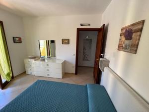 a bedroom with a bed and a dresser and a mirror at Carpa House in Valledoria