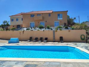 a villa with a swimming pool in front of a house at Portela ALR in Portela da Memória