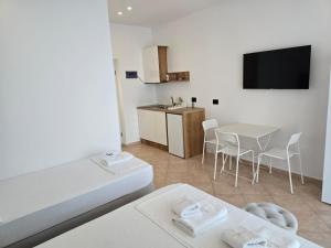 a living room with a table and a kitchen with a tv at Rei Hotel in Borsh