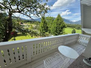 a white balcony with a table and a bench at Vila Katja in Bled