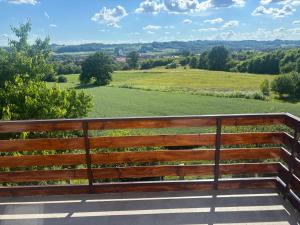 a wooden bench sitting on top of a field at Apartman Bojan in Prnjavor