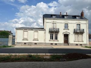 an old white building with a porch and a door at Augustodun'Home in Autun