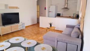 a living room with a couch and a tv and tables at Horizon Isla Tabarca in El Cabo de Gata