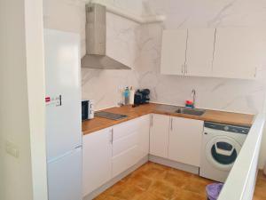 a kitchen with white cabinets and a washing machine at Horizon Isla Tabarca in El Cabo de Gata +6 photos