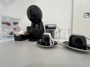 a coffee maker and two cups on a counter at Kalispera Rooms in Scalea