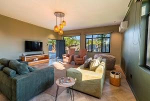 ein Wohnzimmer mit Sofa und Fernseher in der Unterkunft DIE Stoep in Uis