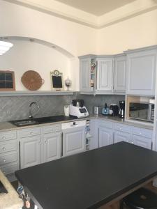 a kitchen with white cabinets and a black counter top at Augustodun'Home in Autun +15 photos