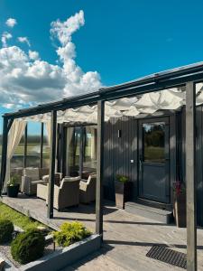 a house with acovered porch with couches at Retrīts MIGLA with sauna included in Stacija )) (( Blukas +20 photos