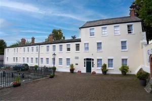 a large white house with a fence in front of it at St Winefride's Guesthouse in Holywell