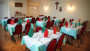 a room with tables and chairs with red and green napkins at St Winefride's Guesthouse in Holywell
