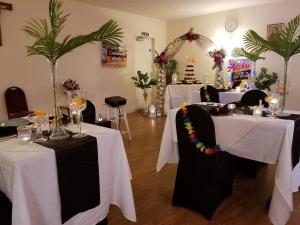 a room with two tables with white and black tablecloths at St Winefride's Guesthouse in Holywell