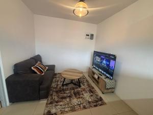 a living room with a couch and a flat screen tv at Crescent Bud in Durban