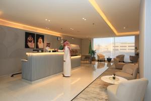 a lobby with a woman standing at a counter at Bawabat Alnakhil For Hotel Apartments in Riyadh +60 photos