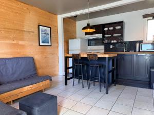 a kitchen with a bar and a couch in a room at Attitude Montagne in Saint Adolphe D'Howard