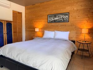 a bedroom with a large bed with a wooden wall at Attitude Montagne in Saint Adolphe D'Howard