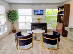 a living room with a table and chairs and a tv at Days Inn by Wyndham Donalsonville in Donalsonville +12 photos