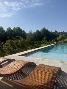 a wooden bench sitting next to a swimming pool at Quinta dos Tojais Hotel Rural in Celorico de Basto