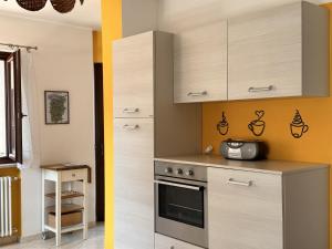 a kitchen with white cabinets and a stove at Maison Josephine in Chiusa di Pesio