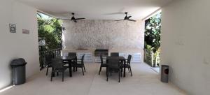 a dining room with black chairs and a table at Akumalito Santamar in Akumal