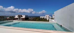 a swimming pool on top of a building with a view of the ocean at Akumalito Santamar in Akumal