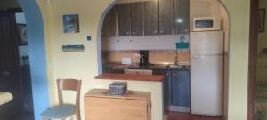 a kitchen with a refrigerator and a table and a chair at Sunshines on the sea in Almuñécar