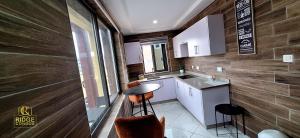 a small kitchen with a table and a sink at Ridge Condos Hotel - Phase Three in Kumasi