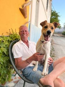 a man sitting in a chair with a dog on his lap at Casa Mathilda in Fornes
