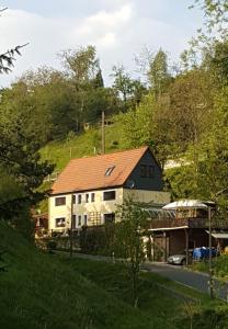 a house with a red roof on the side of a road at Ferienwohnung Auszeit in Hohnstein