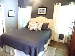 a bedroom with a large bed with two pillows at The Lantern in Pensacola