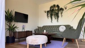 a living room with a green couch and a table at Polaris Astra Bay in Lepetani