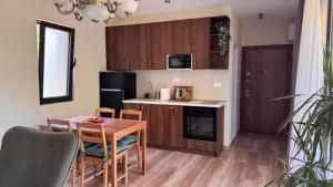 a kitchen with a wooden table and a dining room at Polaris Astra Bay in Lepetani +10 photos