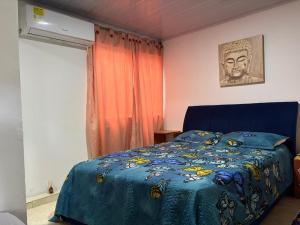 a bedroom with a bed with a blue comforter at Playa Zen Rodadero in Rodadero