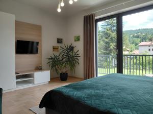 a bedroom with a bed and a large window at Apartament Parkowa 8 in Myślenice