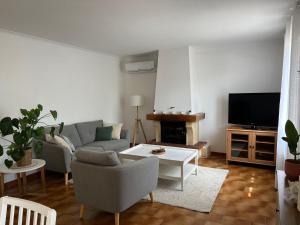 a living room with a couch and a tv at La Maison d'Orange - Au calme à 2 pas du Théâtre Antique in Orange