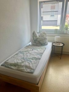 a bed sitting in a room with a window at Ferienwohnung Nähe Autobahn Ruhige Lage für Familien & Monteure in Erolzheim