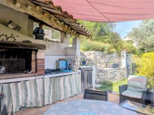 a patio with a fireplace and a table and chairs at Tiny house - Drap, France in Drap